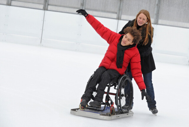 Eisgleiter, mit dem Rollstuhl aufs Eisfeld.